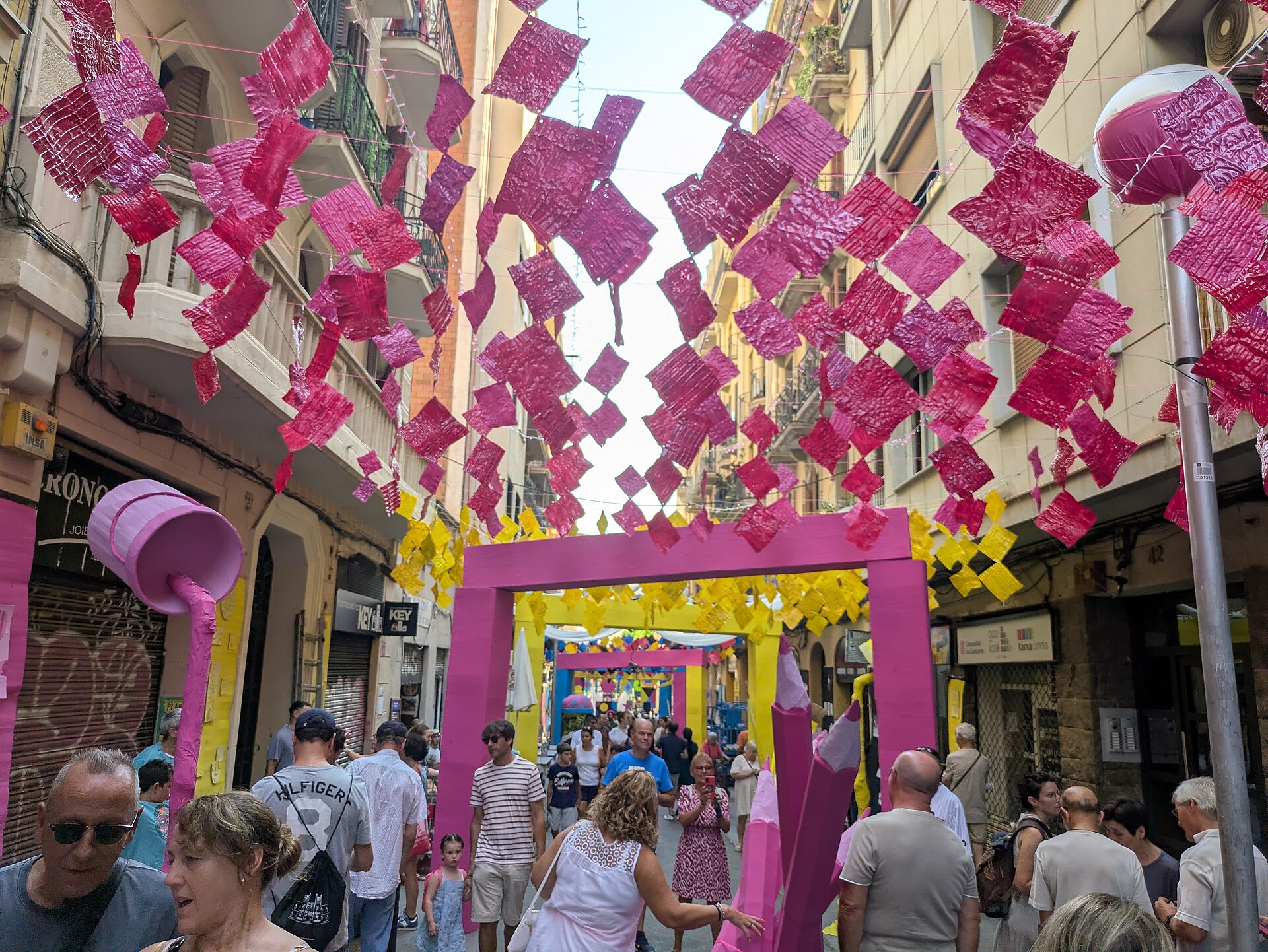 Visitantes paseando de día bajo la decoración del carrer de Puigmartí durante la Festa Major de Gràcia 2025.